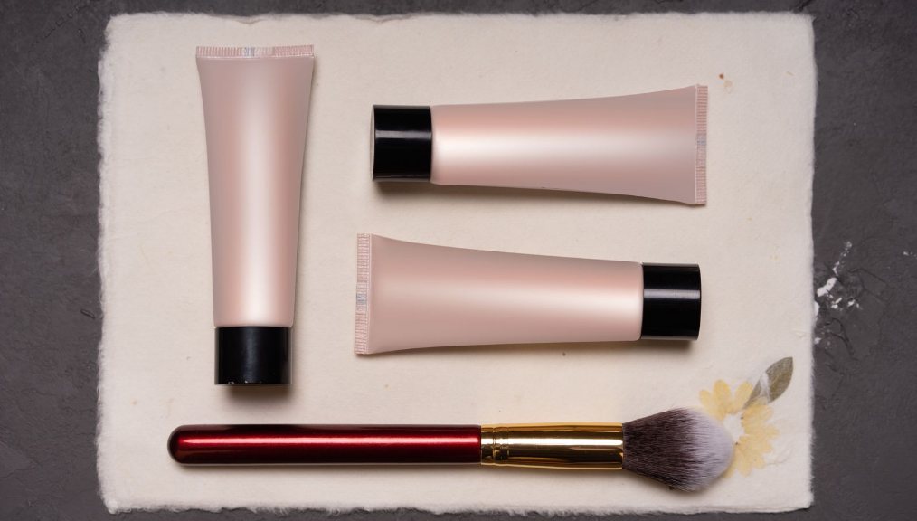 Cosmeticos y brocha de maquillaje sobre la mesa